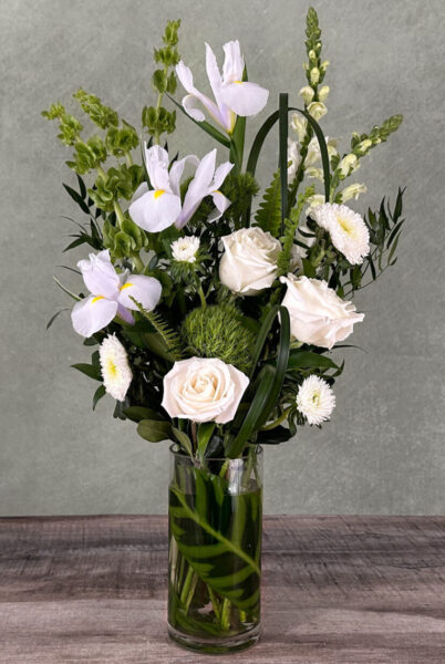 Irish Light is a white designer's choice arrangement featuring premium white flowers in a tall glass vase